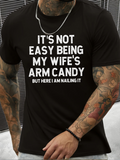 Men's T-Shirt Its Not Easy Being My Wifes Arm Candy But Here I Am Nailing It Bold Statement Text Black Cotton T Shirt