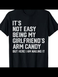 Men's T-Shirt Its Not Easy Being My Girlfriends Arm Candy Nailing It Bold Slogan Statement White Letters Black Shirt