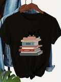 Women's T-Shirt Cozy Evening With Curious Black Cat Resting On Tall Book Stack