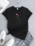 Women's T-Shirt Minimalist Hand Gesture With Rising Pink Heart Motif On Elegant Black T Shirt
