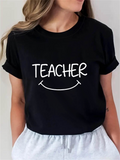 Women's T-Shirt Curved Handwritten Smiling Text Under Playful Teacher Print