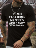 Men's T-Shirt Its Not Easy Being My Wifes Arm Candy But Here I Am Nailing It Bold White Letters Across Solid Black Cotton Shirt
