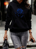 Women's Hoodie Vivid Blue Flower Blooming Among Lush Leaves Under Soft Light Rose