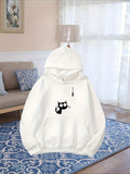Women's Hoodie Curious Black Cat Reaching Toward Dangling String Alone Under Soft Light Cat