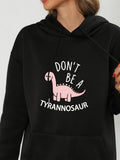 Women's Hoodie Dont Be A Tyrannosaur Smiling Pink Cartoon Dinosaur Under Playful Text Dinosaur